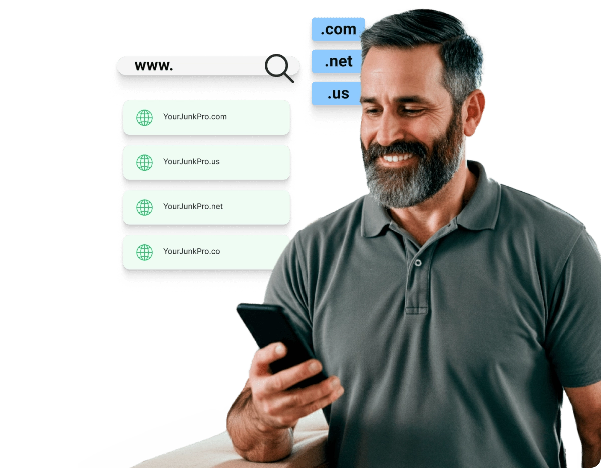 Man smiling at his phone, choosing a custom domain for his junk removal business, with options like .com, .net, and .us displayed.